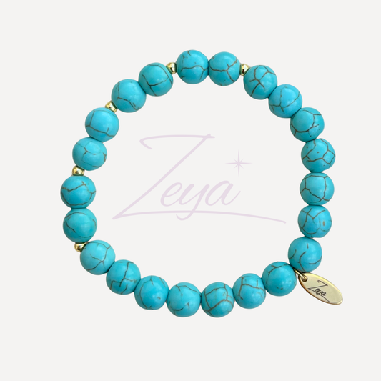 Le Bracelet Bora-Bora est une invitation au voyage et à l'exploration. Composé de turquoise et de perles dorées, il incarne l’esprit des îles lointaines, où les eaux cristallines rencontrent les plages de sable fin. 