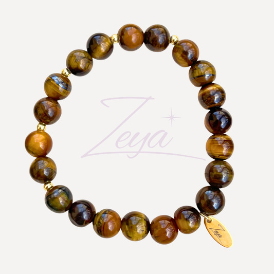 Le Bracelet Bellissima est une œuvre d'art qui marie la puissance de l'œil de tigre à l'élégance des perles dorées. L'œil de tigre, avec ses nuances chatoyantes de brun et d'or, est une pierre de protection et de confiance. 
