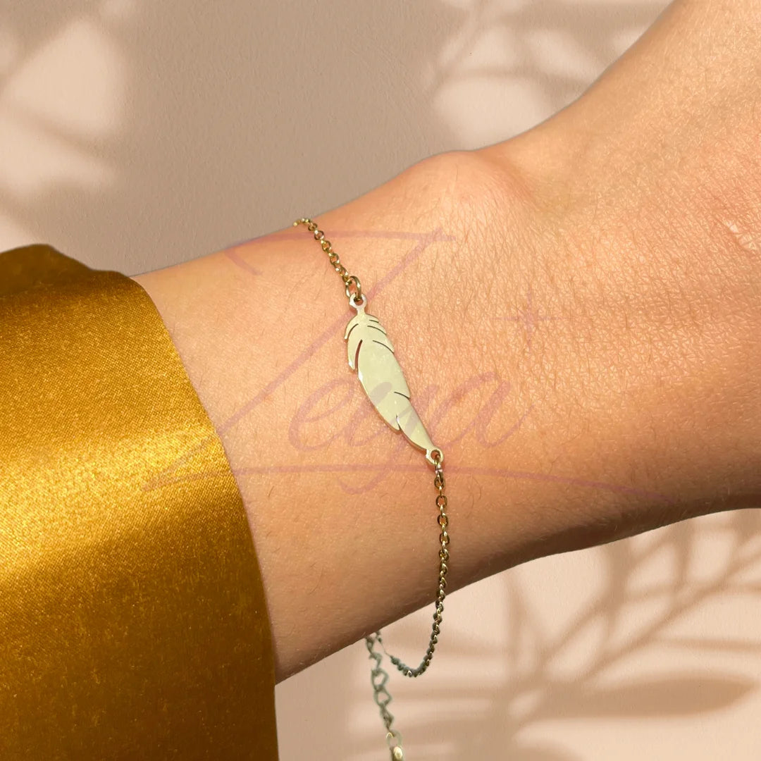 Le Bracelet Feather Glow capture l’essence de la liberté et de la délicatesse. Sa fine chaîne dorée met en valeur un pendentif plume aux lignes épurées, symbole de légèreté, d’inspiration et d’élévation. Raffiné et minimaliste, il incarne l’élégance discrète, parfaite pour sublimer votre poignet avec subtilité et grâce.